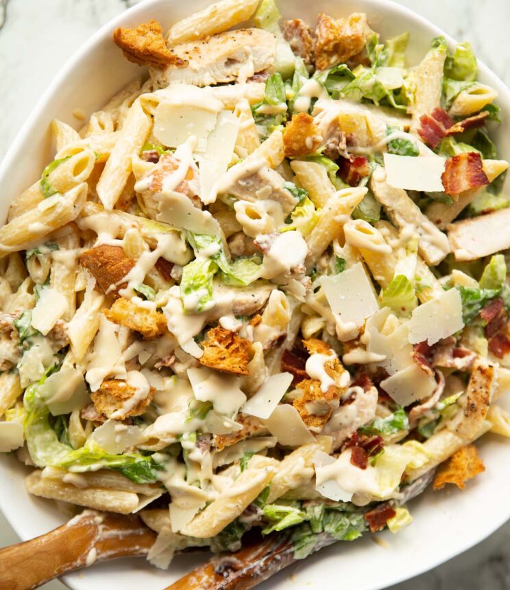 A large bowl of Chicken Caesar Pasta Salad featuring bowtie pasta, shredded chicken, and crunchy croutons.