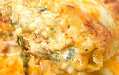 Close-up of creamy chicken lasagna roll-ups with melted mozzarella and sun-dried tomatoes.