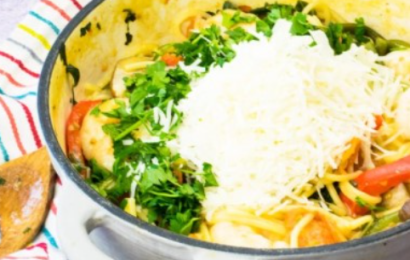 A steaming hot skillet of creamy one-pot prawn and veggie pasta with bright green broccoli and juicy pink shrimp.