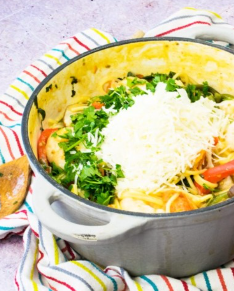 A steaming hot skillet of creamy one-pot prawn and veggie pasta with bright green broccoli and juicy pink shrimp.