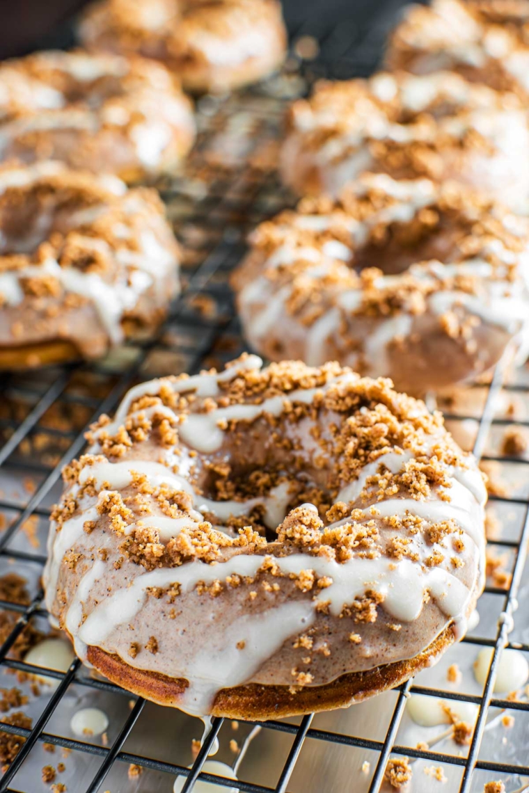Warm baked donuts with a cinnamon sugar swirl and white cream cheese icing.