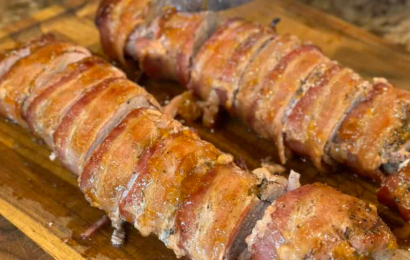 A perfectly sliced juicy roasted pork tenderloin coated in a sticky, golden brown sugar glaze, served on a white serving platter with a sprinkle of fresh parsley.