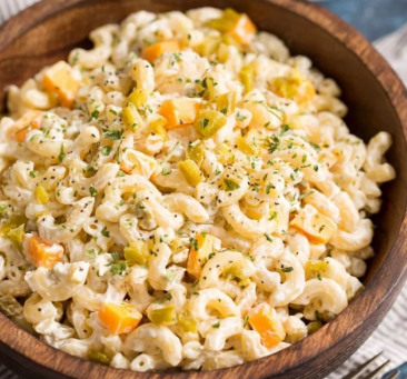A large glass bowl filled with a creamy Jalapeno Popper Macaroni Salad, topped with crispy chopped bacon, sliced fresh jalapenos, and shredded cheddar cheese.
