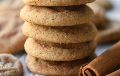 A stack of thick, chewy brown butter snickerdoodle cookies coated in a sparkling layer of cinnamon sugar, showing soft and pillowy centers.