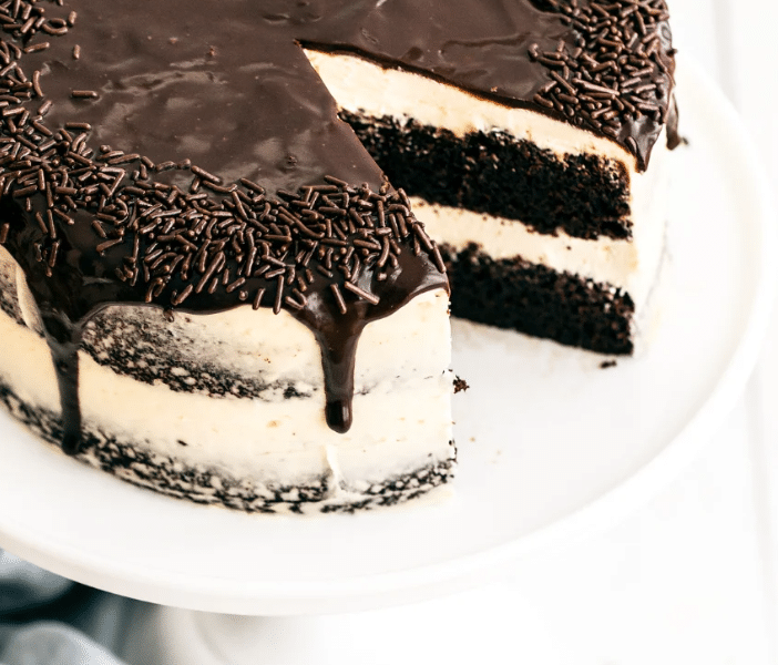 A tall, incredibly moist slice of dark Guinness Chocolate Cake topped with a generous, fluffy layer of Baileys Irish Buttercream frosting.