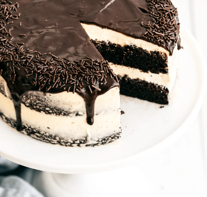 A tall, incredibly moist slice of dark Guinness Chocolate Cake topped with a generous, fluffy layer of Baileys Irish Buttercream frosting.